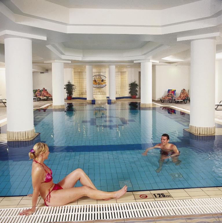 a man and a woman sitting in a swimming pool at Nissiana Hotel & Bungalows in Ayia Napa