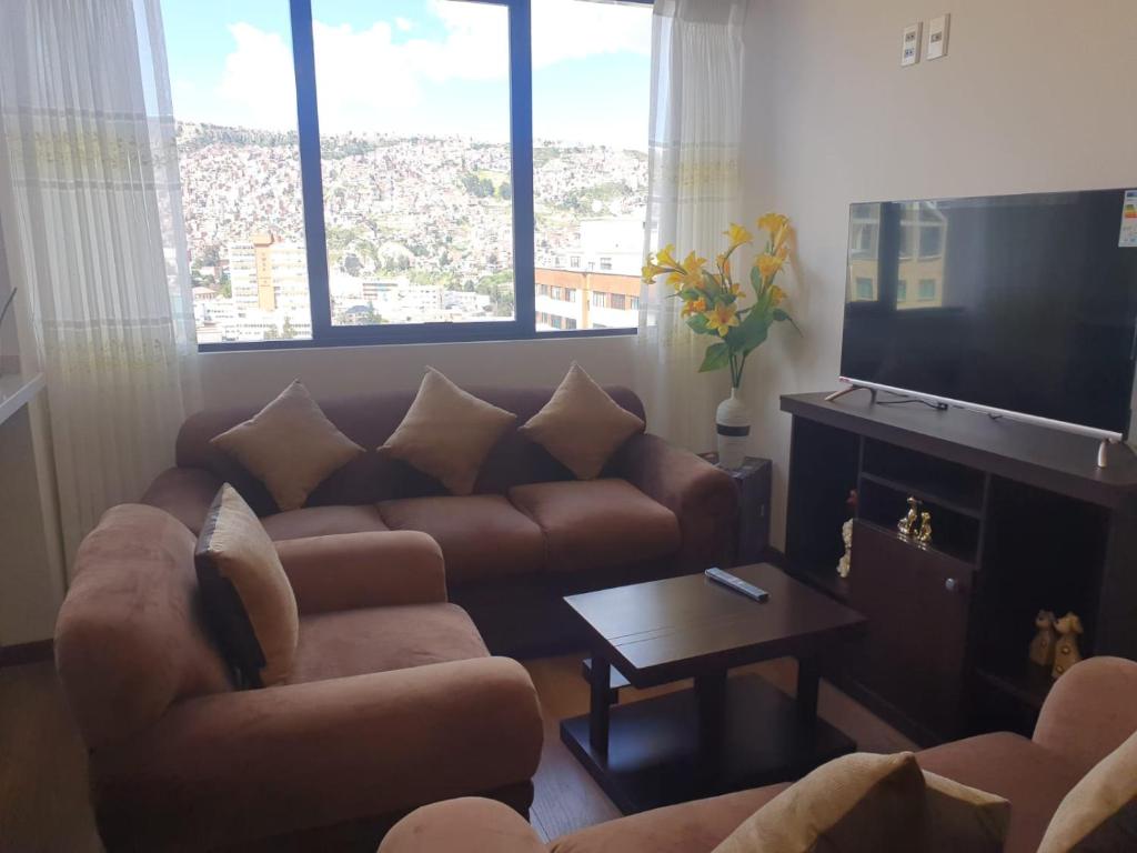sala de estar con sofá y TV en Nico&Style Apartment VIP, en La Paz