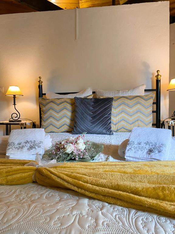 a large bed with a blanket and flowers on it at Moinho Da Pena - Alojamento Local in Bairro