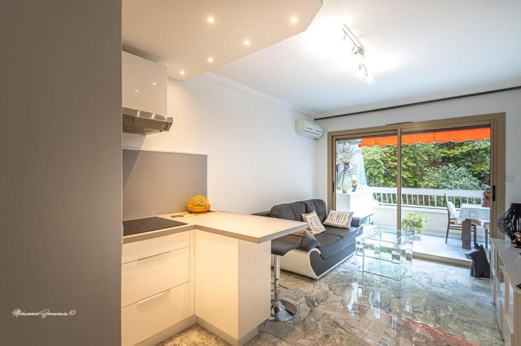 een keuken en een woonkamer met een bank en een tafel bij Ô 27 Fleurie Cannes in Cannes
