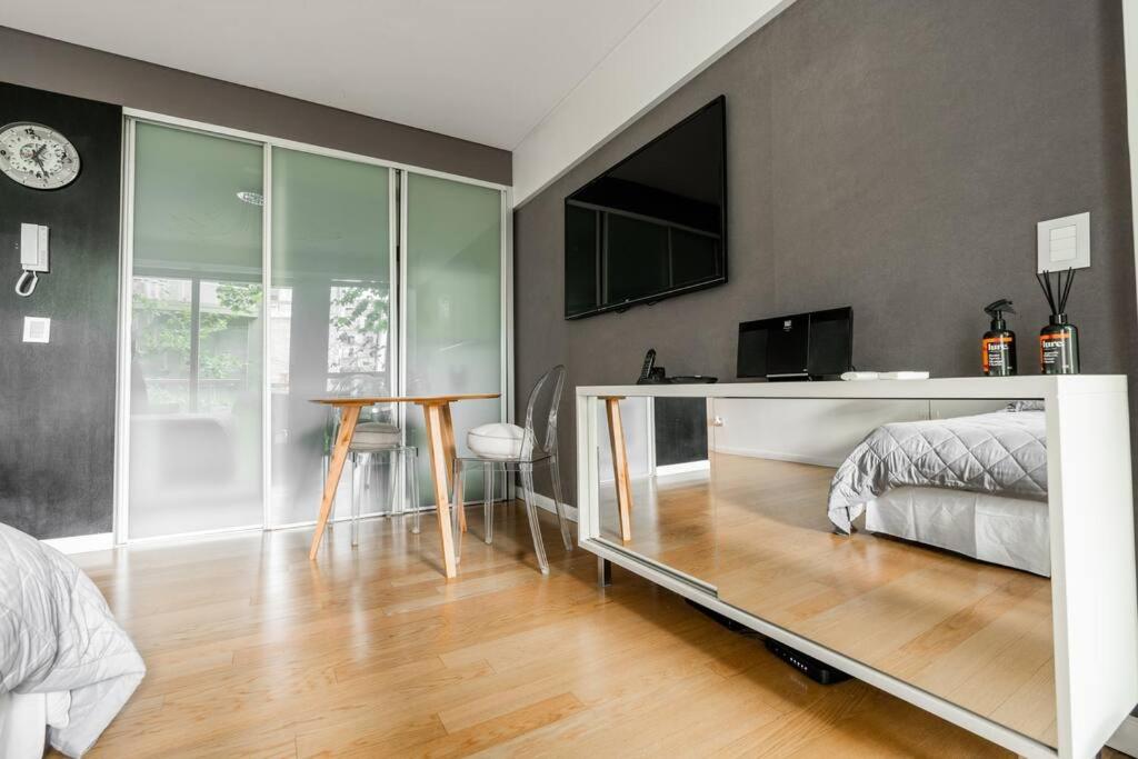 1 dormitorio con 1 cama y TV en la pared en Bello Studio Recoleta en Buenos Aires