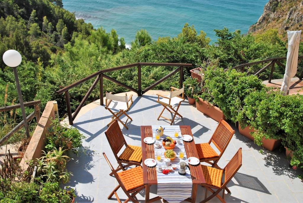 a table and chairs on a patio overlooking the ocean at Villa Arborea in Sperlonga in Sperlonga