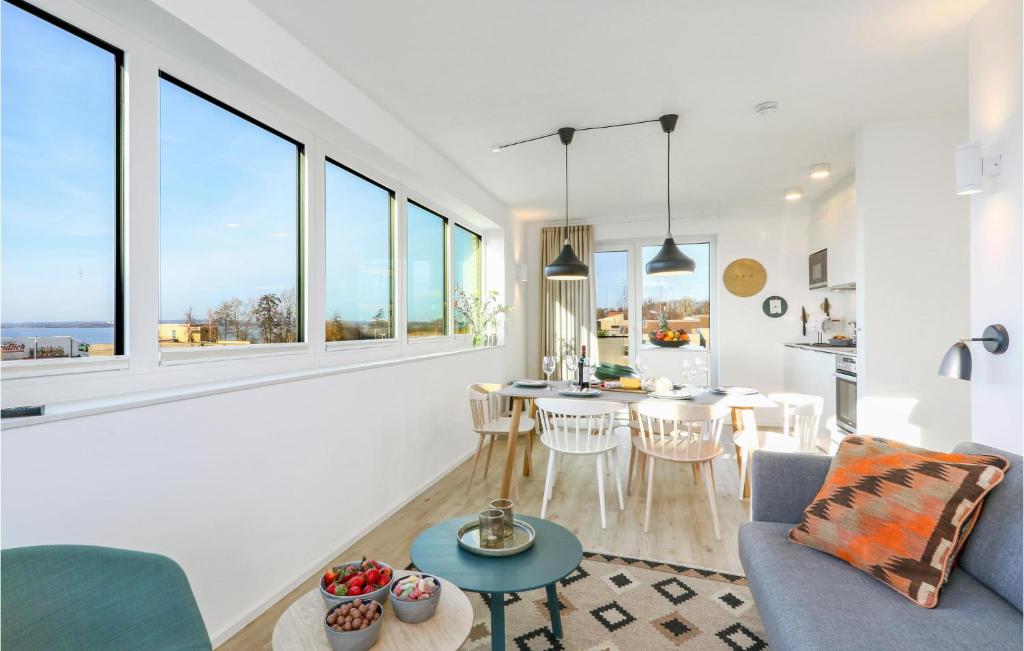 ein Wohnzimmer mit Tisch und Stühlen und Fenstern in der Unterkunft Nice Apartment In Lembruchdümmer See in Lembruch