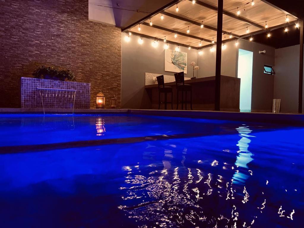 a large swimming pool with blue lighting in a room at Suites Marvento in Ensenada