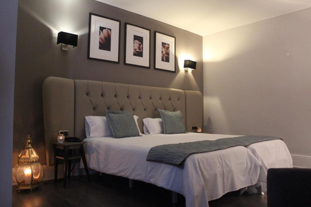a bedroom with a large bed with two pictures on the wall at Hotel Bienestar Termas De Vizela in Vizela