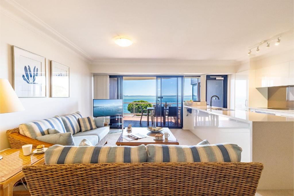 a kitchen and living room with a view of the ocean at Florentine 14 - 11 Columbia Close Aircon Wifi unsurpassed water views in Nelson Bay