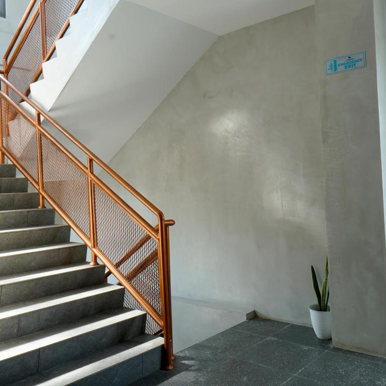 a staircase with a metal railing and a plant at DParagon Jakarta Timur in Jakarta