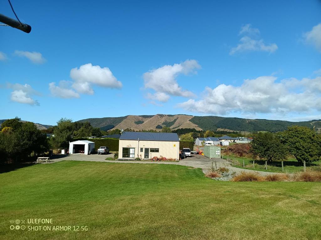 a house in a field with mountains in the background at Flying Plate Saloon in Waimate