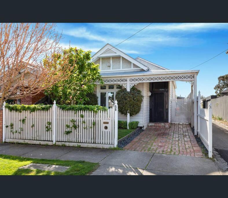une clôture blanche devant une maison blanche dans l'établissement Entire contemporary home in Ascot Vale, à Melbourne