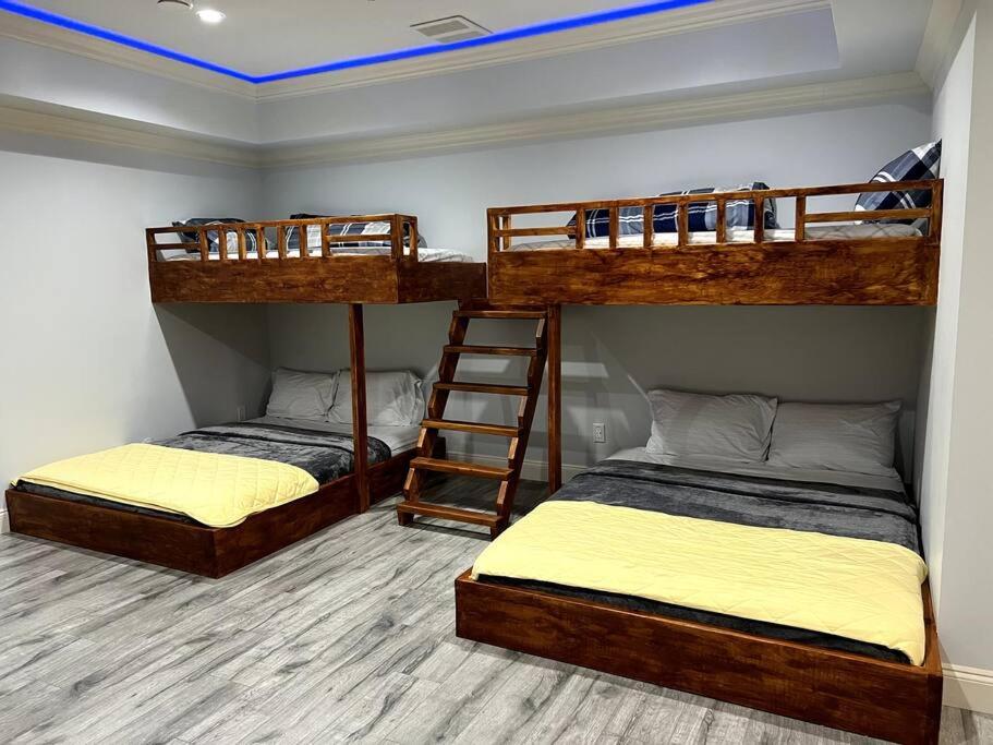 a room with three bunk beds and a ladder at Modern Spacious For Big Group in Abbotsford