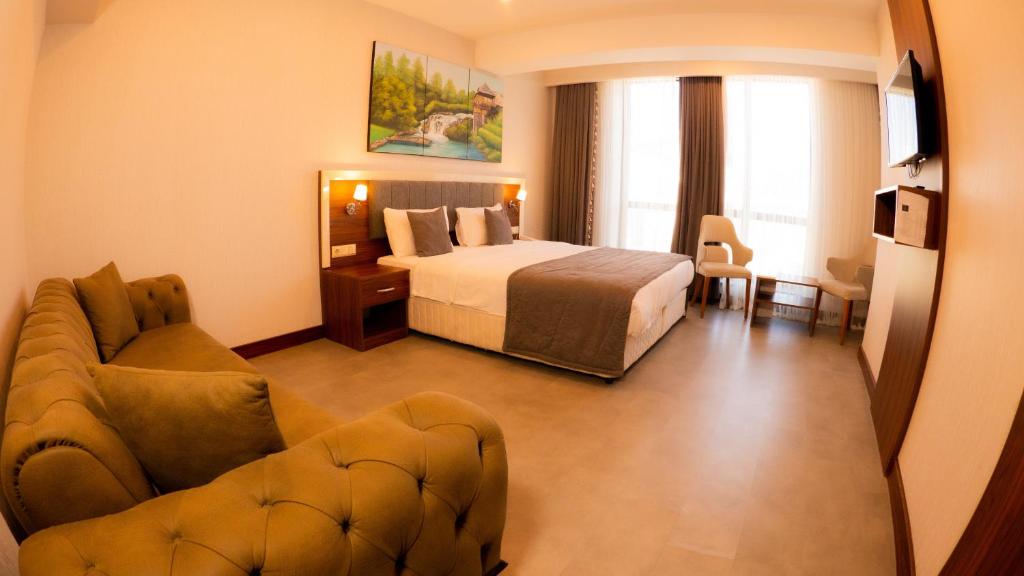 pokój hotelowy z łóżkiem i kanapą w obiekcie Deryaman Hotel Trabzon w mieście Trabzon