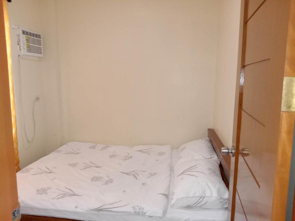 een kleine kamer met een bed met witte lakens bij MAYA HOMES VALENCIA in Valencia