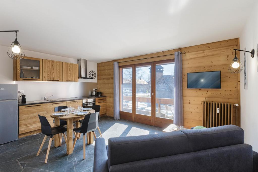 a kitchen and a living room with a couch and a table at Appartement Flégère et Golf - Happy Rentals in Chamonix-Mont-Blanc