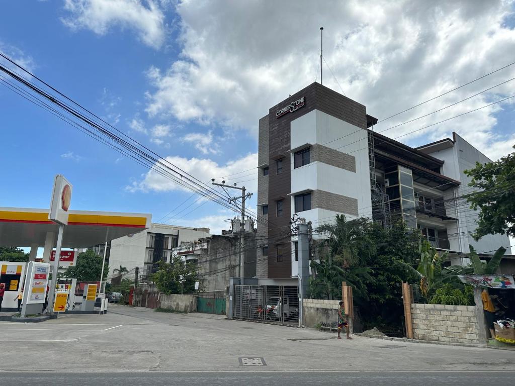 a building on a street with a gas station at Cornerstone Manor Inn in Talamban Viejo