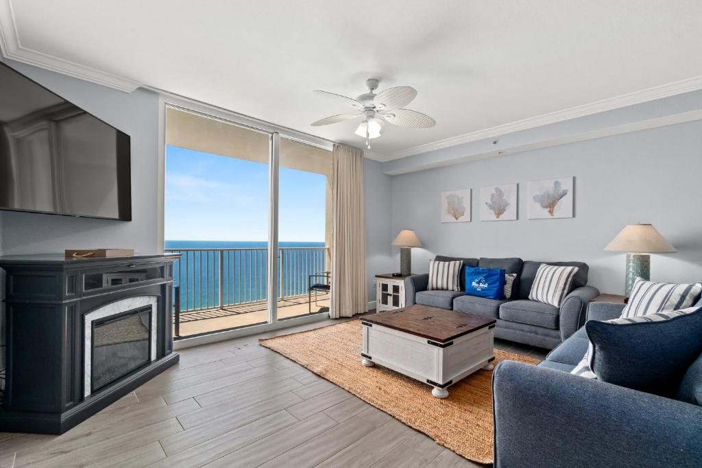 a living room with a couch and a tv and a fireplace at Tidewater Beach Resort 2505 - Sea Gem in Panama City Beach