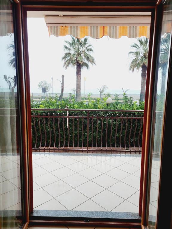a window view of a patio with palm trees at PraiadAmare in Praia a Mare