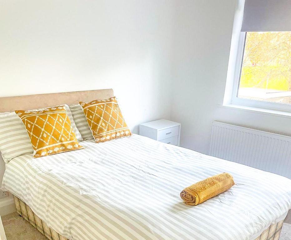 a bed with a wooden object on it in a bedroom at 3-Bed House in London Garden & free parking in Dartford