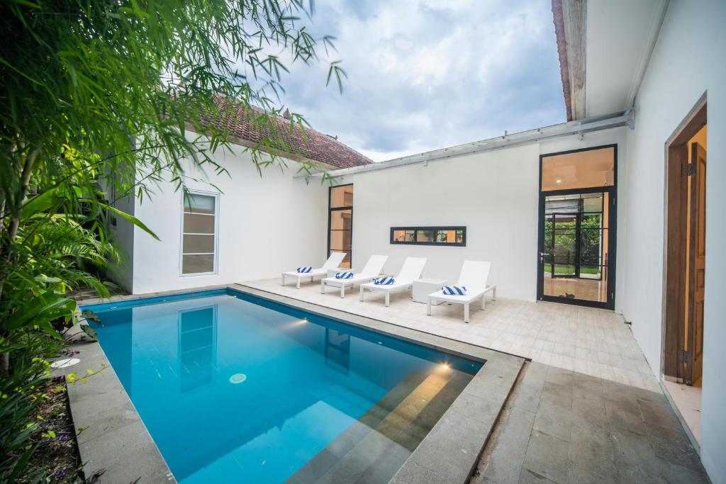 a swimming pool in a house with white walls at Villa Sayang Sanur 111 in Sanur