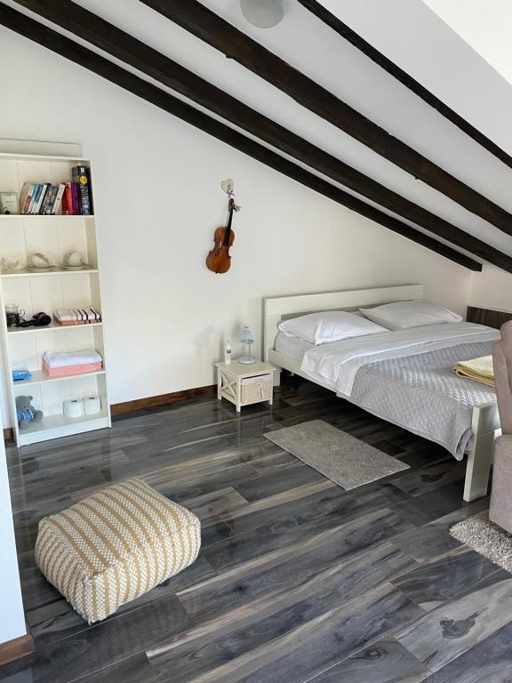 ein Schlafzimmer mit einem Bett und einer Gitarre an der Wand in der Unterkunft Apartment Jovana in Kotor