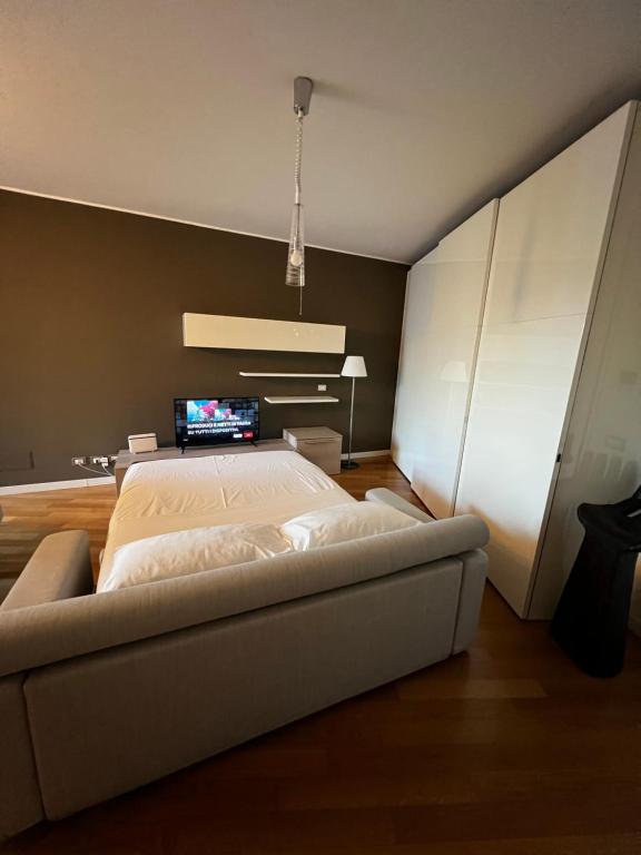 een slaapkamer met een groot bed en een televisie bij Place of peace in Assago