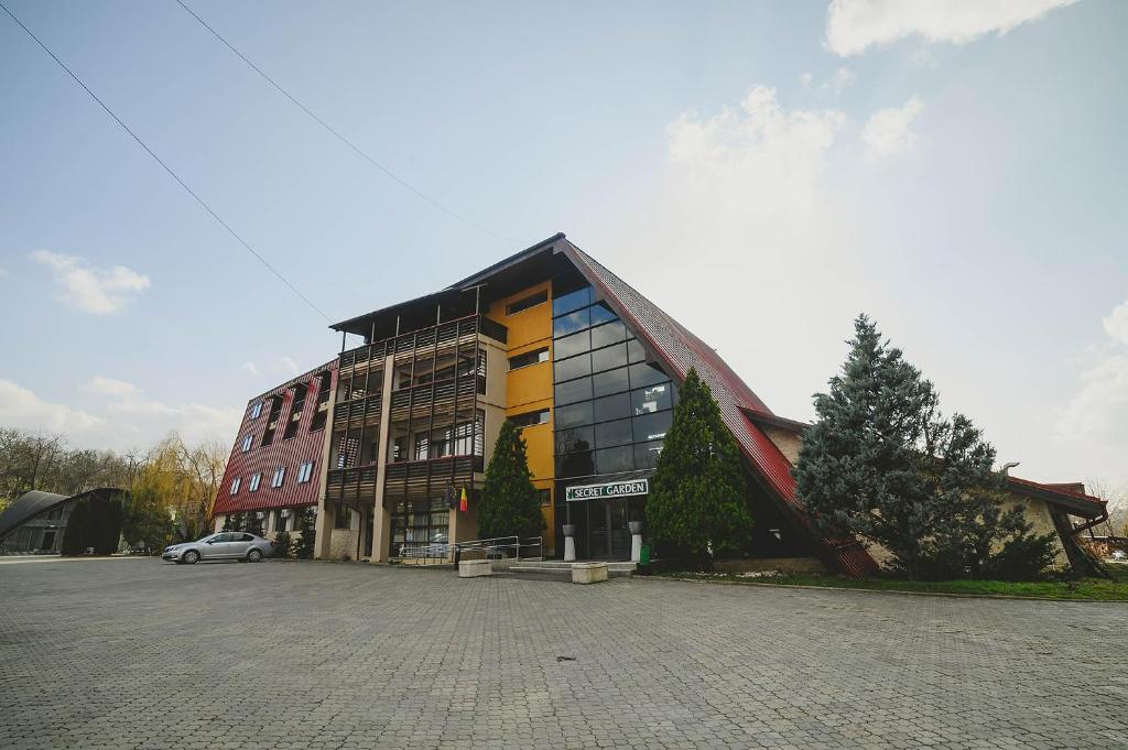 un edificio con un'auto parcheggiata di fronte di Hotel Secret Garden a Baia-Sprie