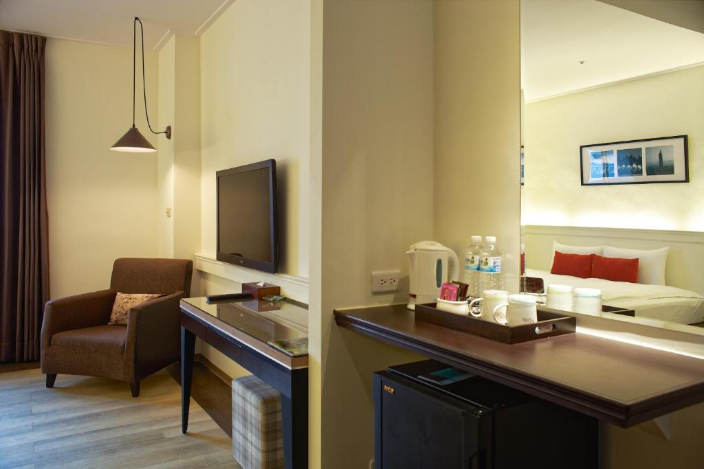 a hotel room with a desk and a room with a bed at 53 Hotel in Taichung