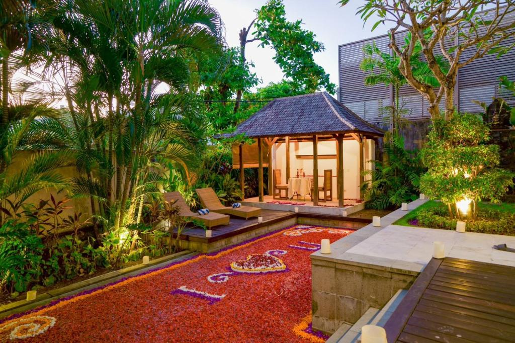 a garden with a gazebo and a red carpet at Bale Gede Luxury Villas in Seminyak