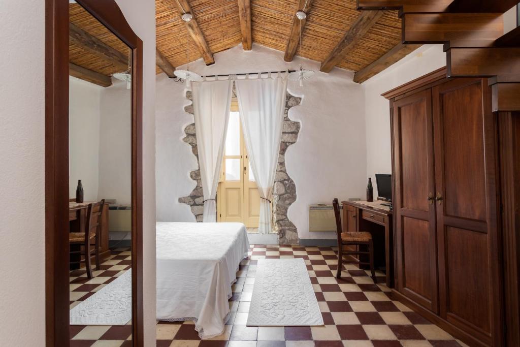 ein Schlafzimmer mit einem Bett und einem karierten Boden in der Unterkunft Locanda di Corte in Bosa