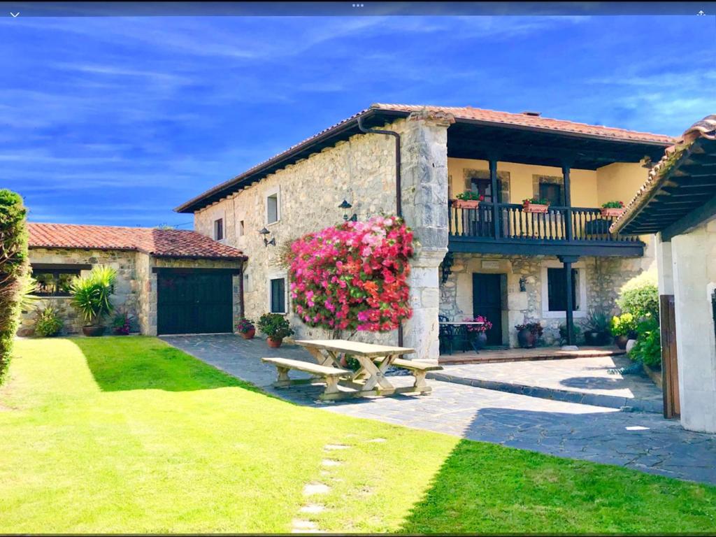 a stone house with a picnic table in the yard at Gran Pedroso de Llanes in Llanes