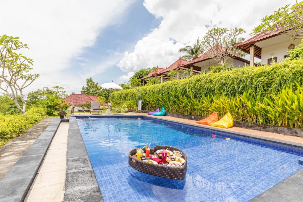 a pool at a villa with a basket of toys at Sarivanna Penida in Nusa Penida