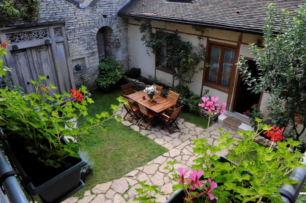 un jardín con una mesa de madera y algunas flores en B&B Chez Marie, en Beaune