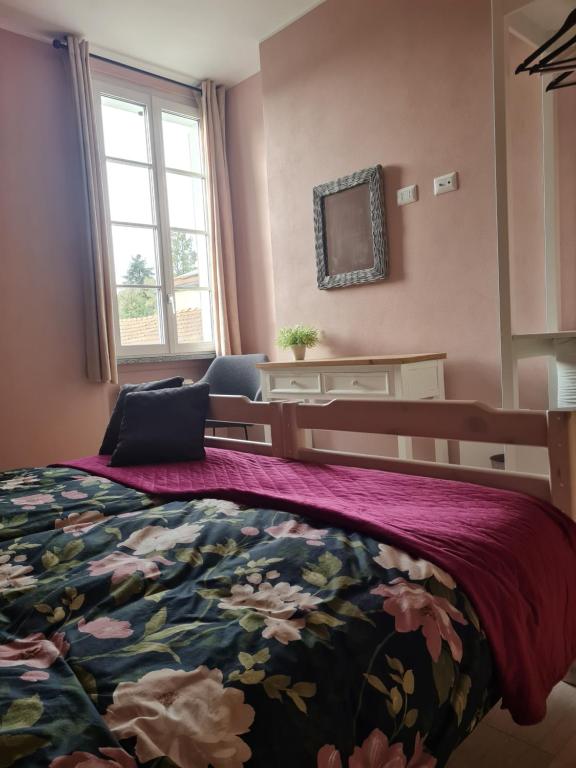 1 dormitorio con 1 cama con colcha de flores en Benvenuto, en Venegono Superiore