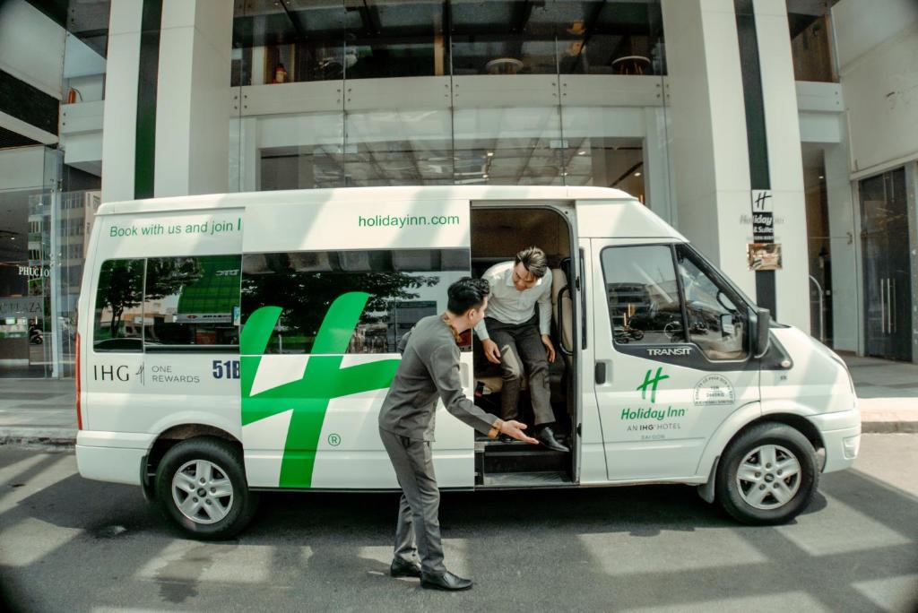 two men are standing in the back of a van at Holiday Inn & Suites Saigon Airport by IHG in Ho Chi Minh City