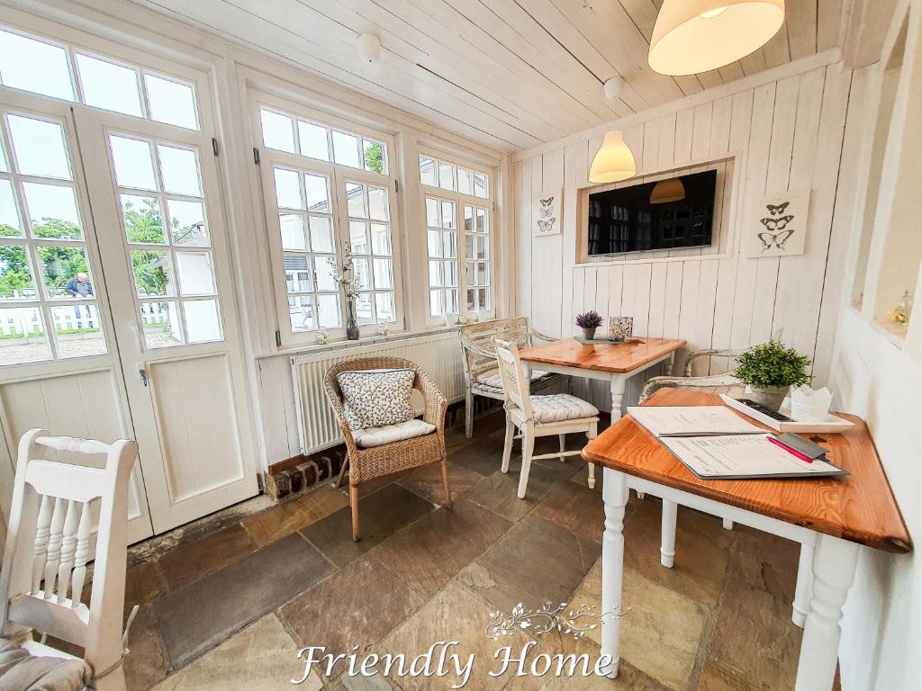 a room with a table and chairs and windows at Friendly Home - Gemütliches Backsteinhaus in Bornheim