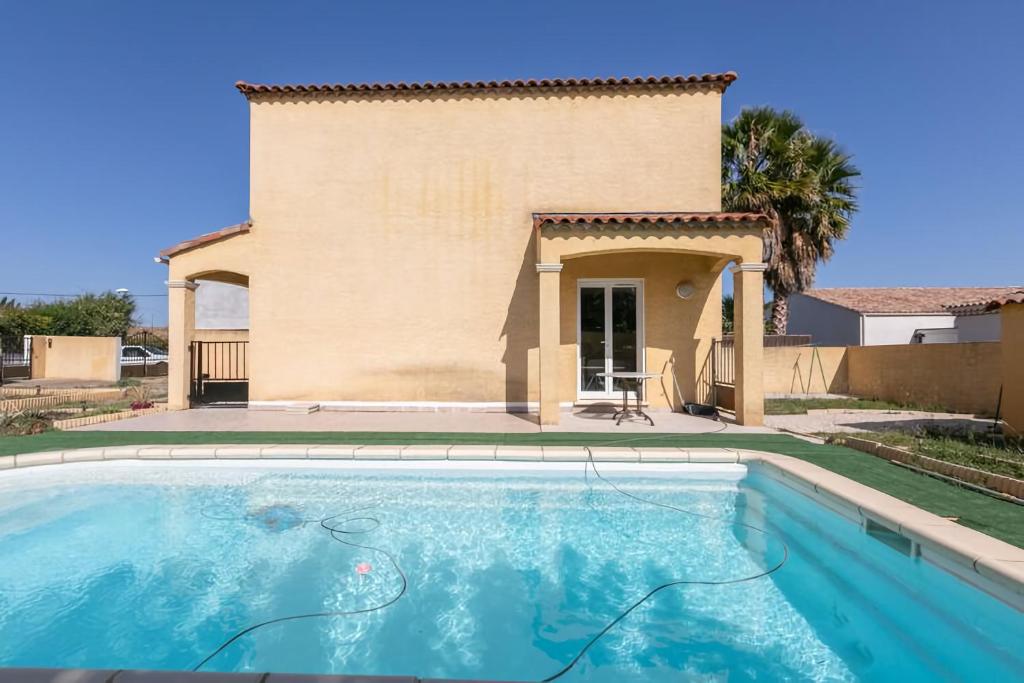 uma piscina em frente a uma villa em Pinet , le calme proche de la mer em Pinet