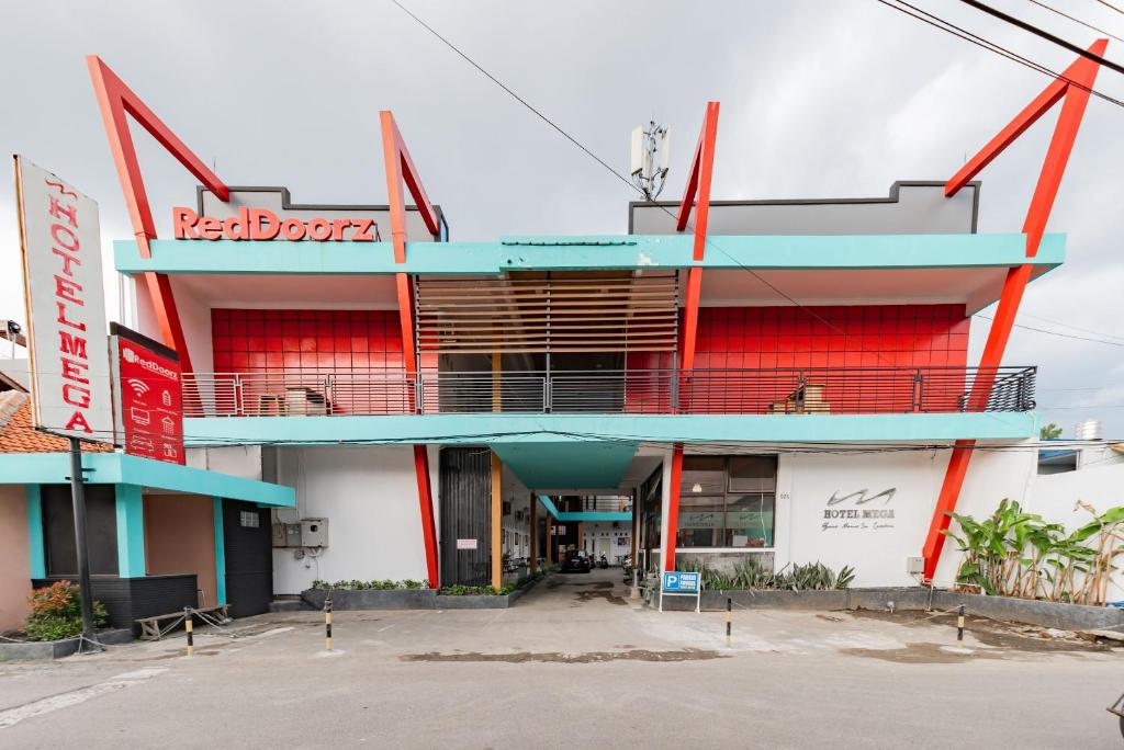 a building with a red and blue facade at RedDoorz near Kejaksan Station Cirebon in Cirebon