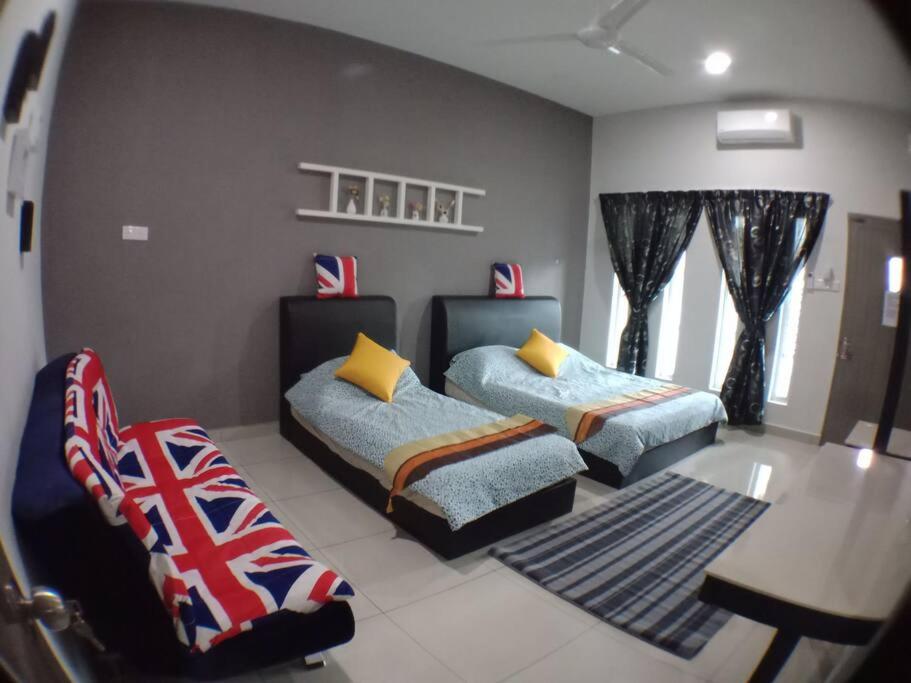 a bedroom with two beds and a table and a chair at AVENUE HOMESTAY 5 Room 4 Toilet 4 MINUTES TO TOWER in Teluk Intan