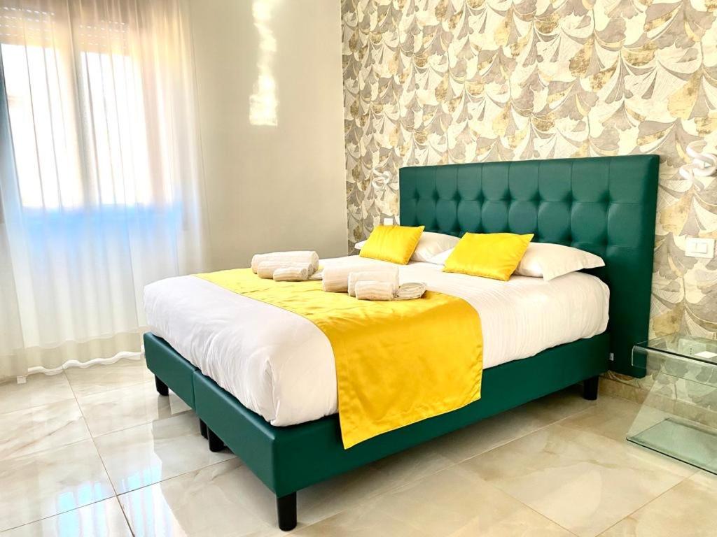 uma cama verde com almofadas amarelas num quarto em RobHouse em Passo Corese