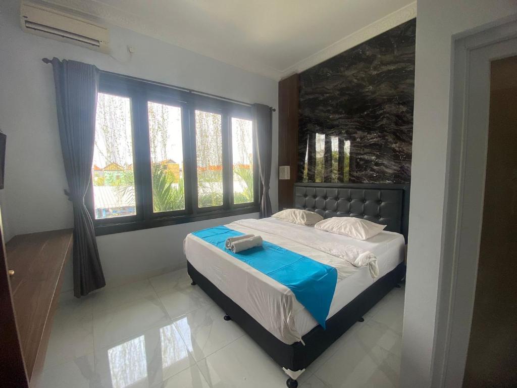 a bedroom with a bed and a large window at Bali Dream Costel in Denpasar