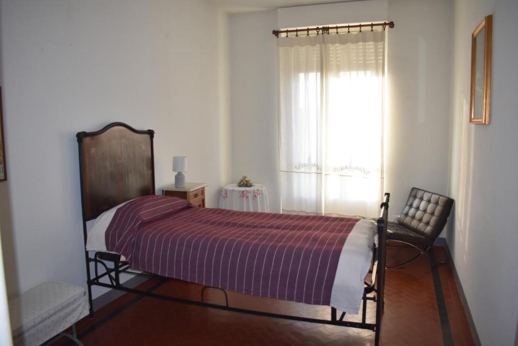 a bedroom with a bed and a window at La Mascarella in Alba
