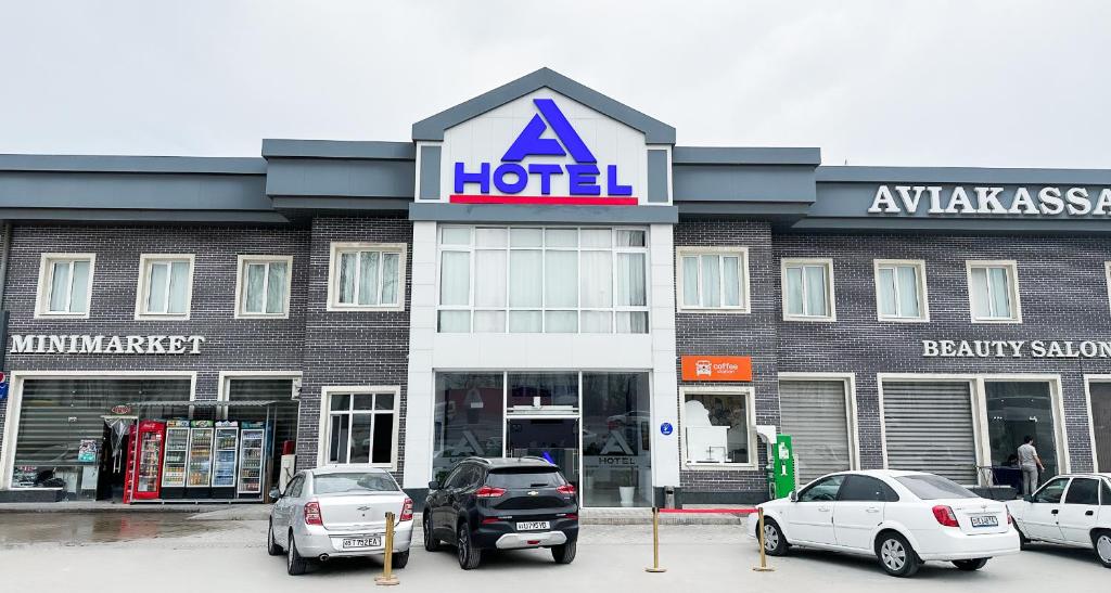 a hotel with cars parked in front of it at A-Hotel Ex Magistral in Solnechnyy