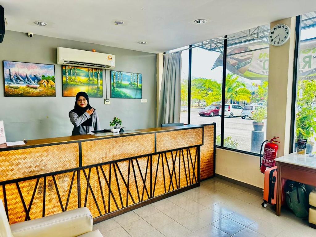 a woman standing behind a counter in a restaurant at Baron Water Front in Kuah