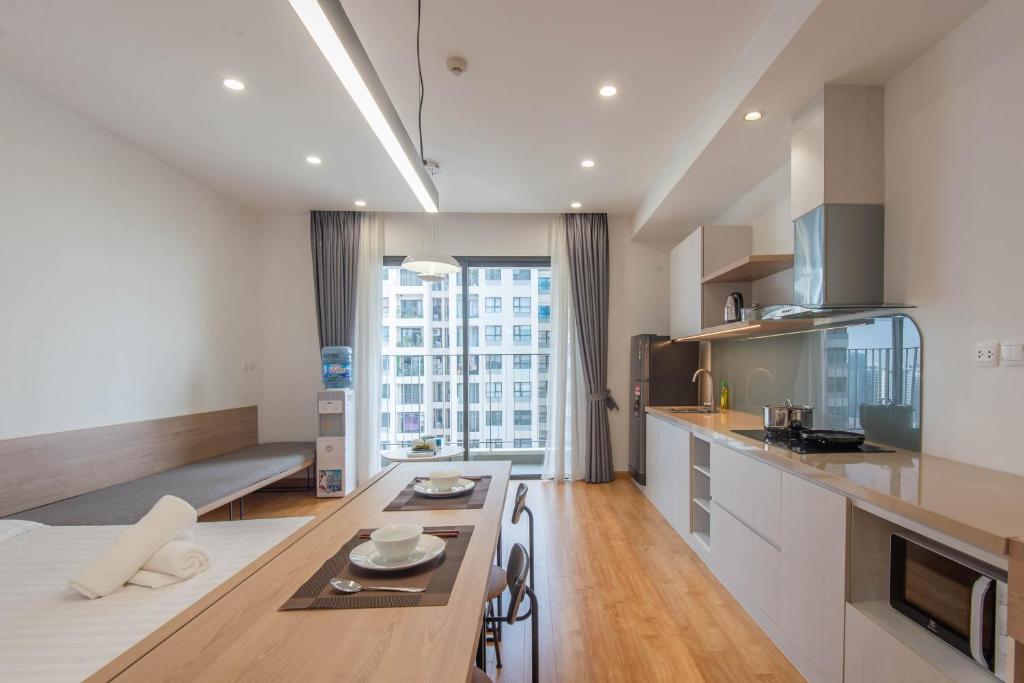 a kitchen with a table and a large window at Cozy Vinhomes D Capital 1 in Hanoi