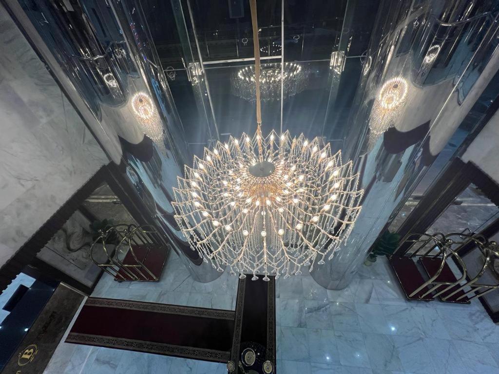 un grand lustre suspendu au plafond d'un bâtiment dans l'établissement فندق بياك أوتيل الروضة, à La Mecque