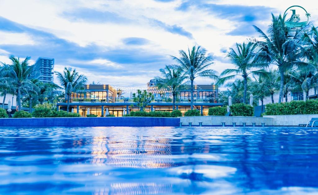 un complexe avec des palmiers et une piscine dans l'établissement Lumina Villas Cam Ranh, Bai Dai beach luxury resort villas, à Cam Ranh