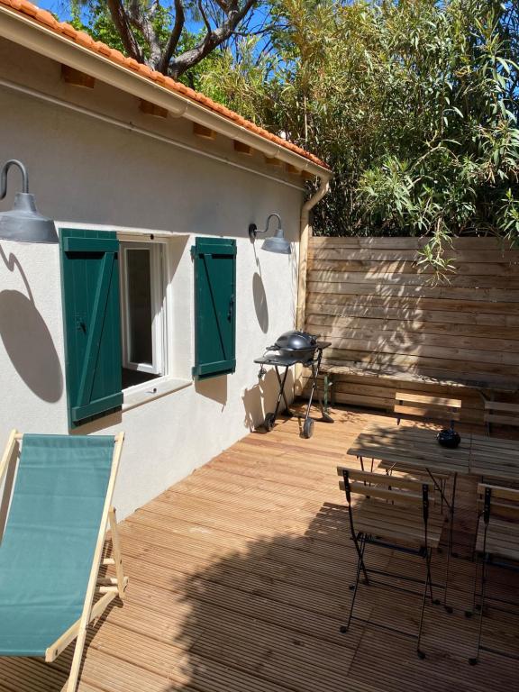 a wooden deck with a table and chairs and a building at Petite Maison typique de ville marseille in Marseille