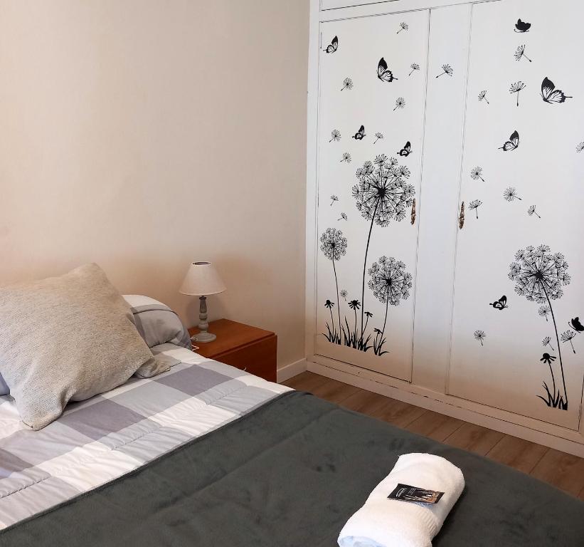 a bedroom with a bed with dandelions and butterflies on the wall at Pensión Fornos in Caldas de Reis