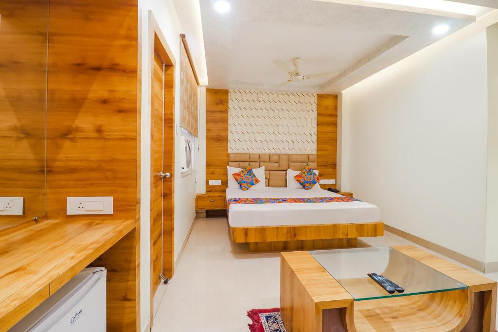 a bedroom with a bed and a desk in a room at FabHotel Holiday Grand in Patna