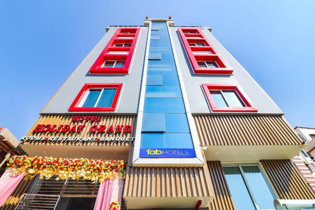 un edificio con ventanas rojas y un cartel en él en FabHotel Holiday Grand en Patna