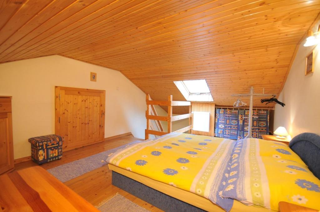sypialnia z łóżkiem i drewnianym sufitem w obiekcie Penzión Mária w mieście Smižany